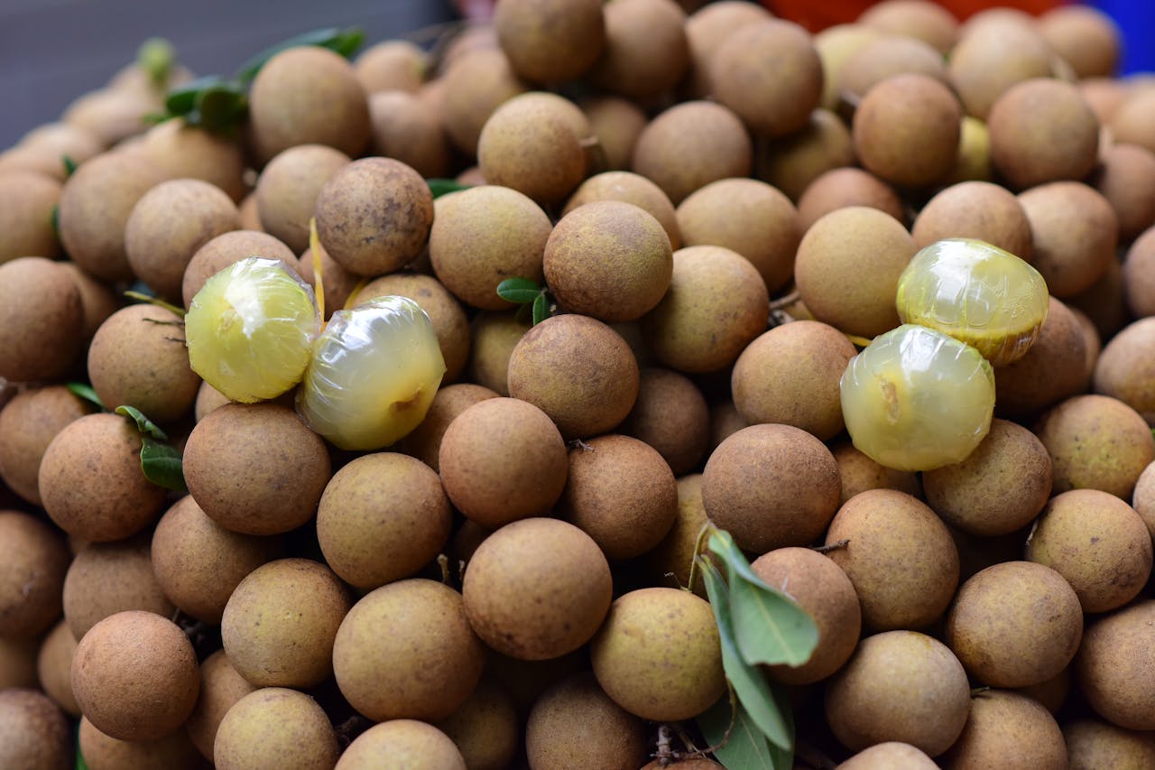 Close-up of fresh longan fruits with a few peeled, highlighting their texture and natural freshness.